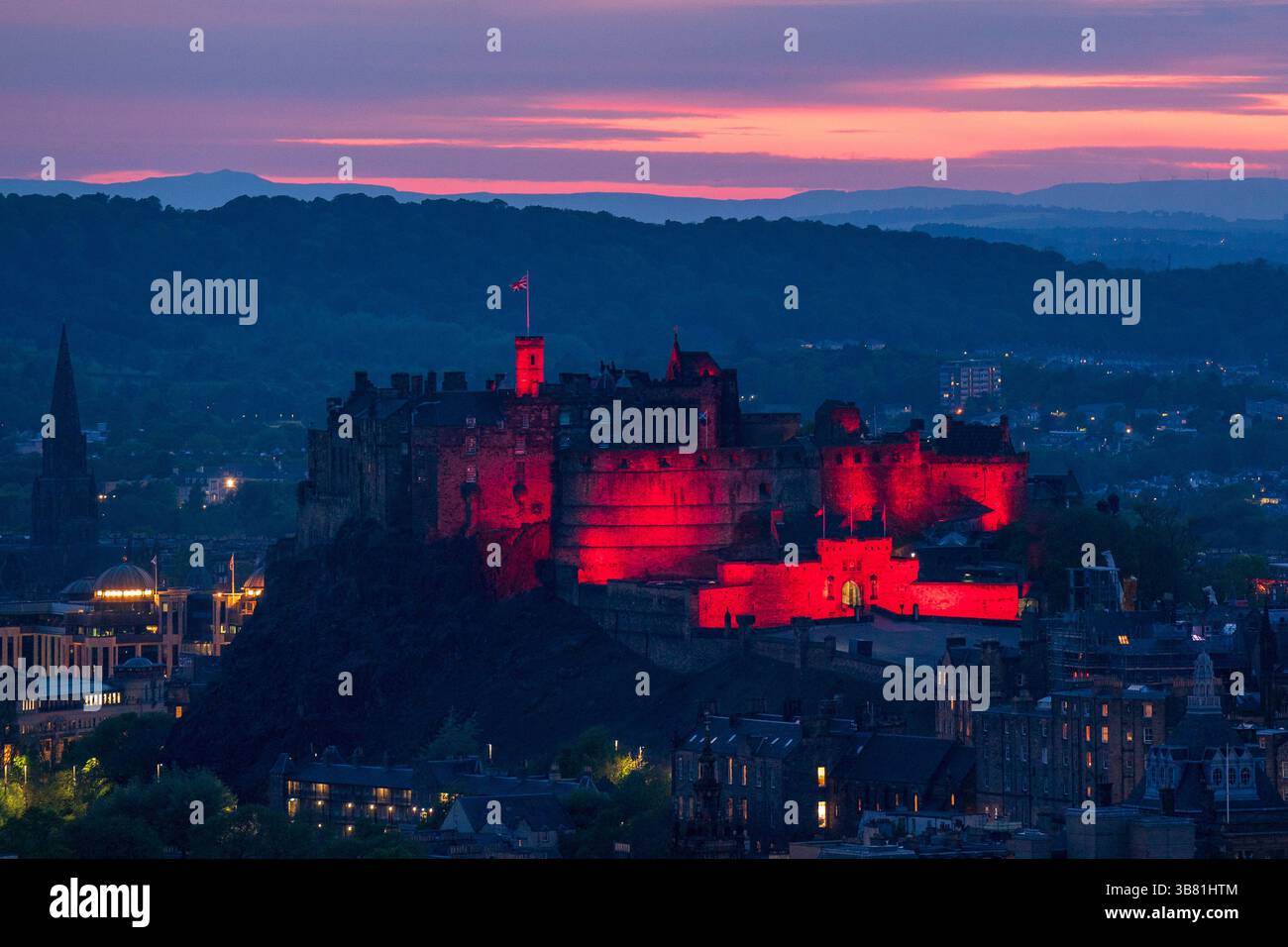 Il Castello di Edimburgo è illuminato di rosso, dato che i monumenti storici di tutto il Regno Unito sono illuminati per il 80° anniversario del VE Day. Data foto: Martedì 6 maggio 2025. Foto Stock