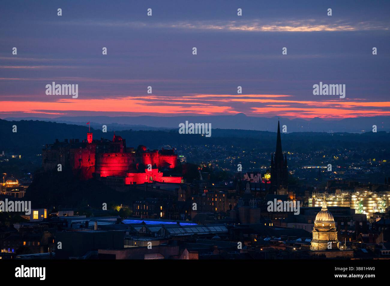 Il Castello di Edimburgo è illuminato di rosso, dato che i monumenti storici di tutto il Regno Unito sono illuminati per il 80° anniversario del VE Day. Data foto: Martedì 6 maggio 2025. Foto Stock