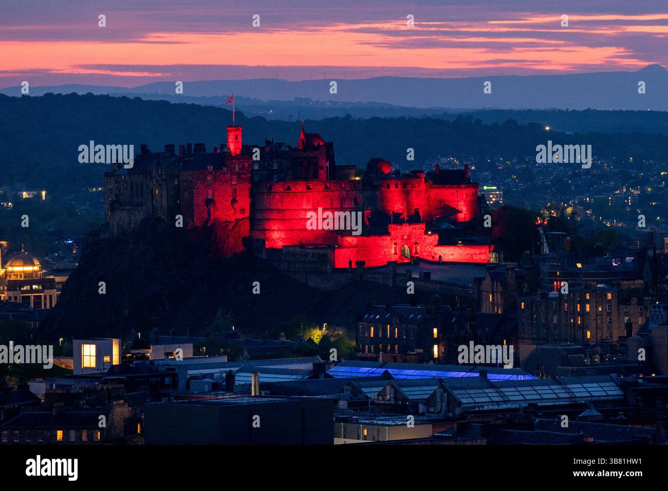 Il Castello di Edimburgo è illuminato di rosso, dato che i monumenti storici di tutto il Regno Unito sono illuminati per il 80° anniversario del VE Day. Data foto: Martedì 6 maggio 2025. Foto Stock