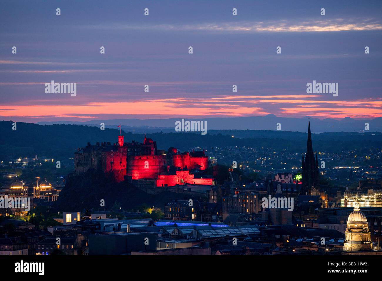 Il Castello di Edimburgo è illuminato di rosso, dato che i monumenti storici di tutto il Regno Unito sono illuminati per il 80° anniversario del VE Day. Data foto: Martedì 6 maggio 2025. Foto Stock