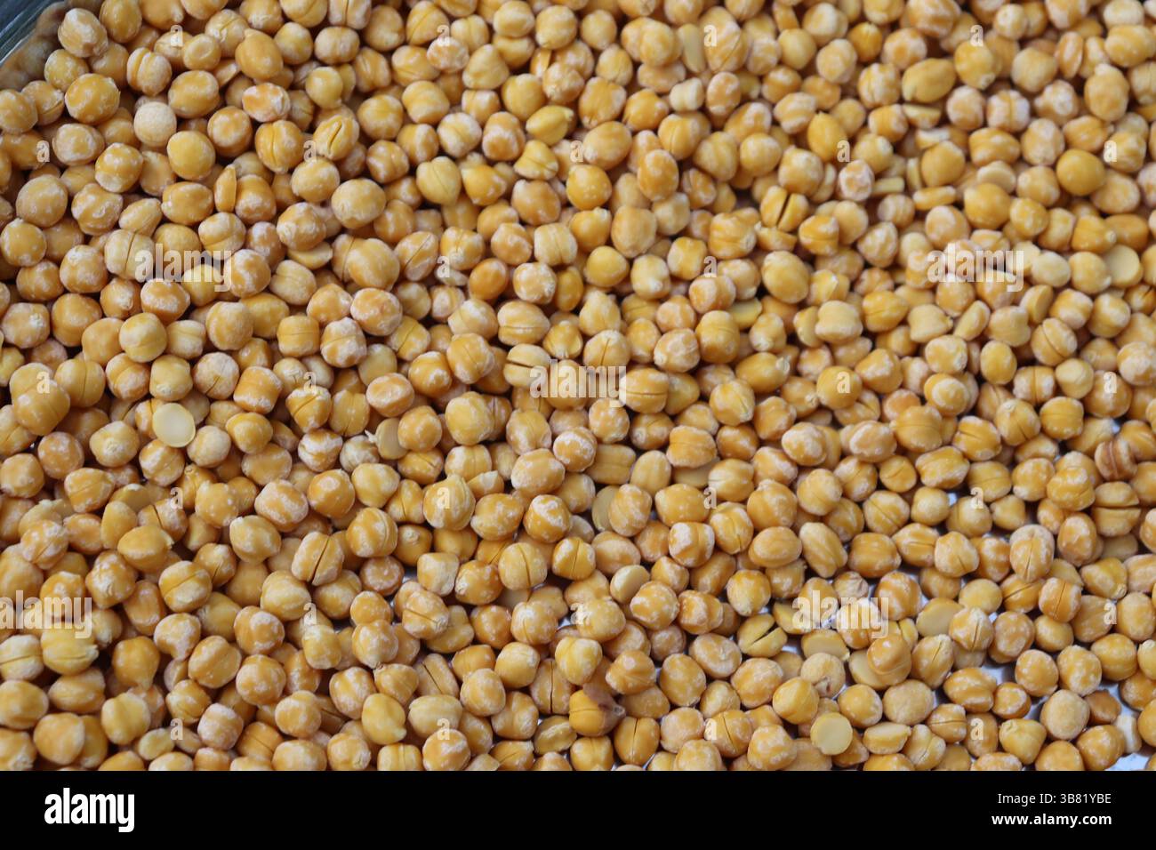 Primo piano superiore visualizza una moltitudine di piselli disidratati gialli. Questi legumi hanno una forma liscia e sferica, fornendo interesse visivo con la loro c Foto Stock