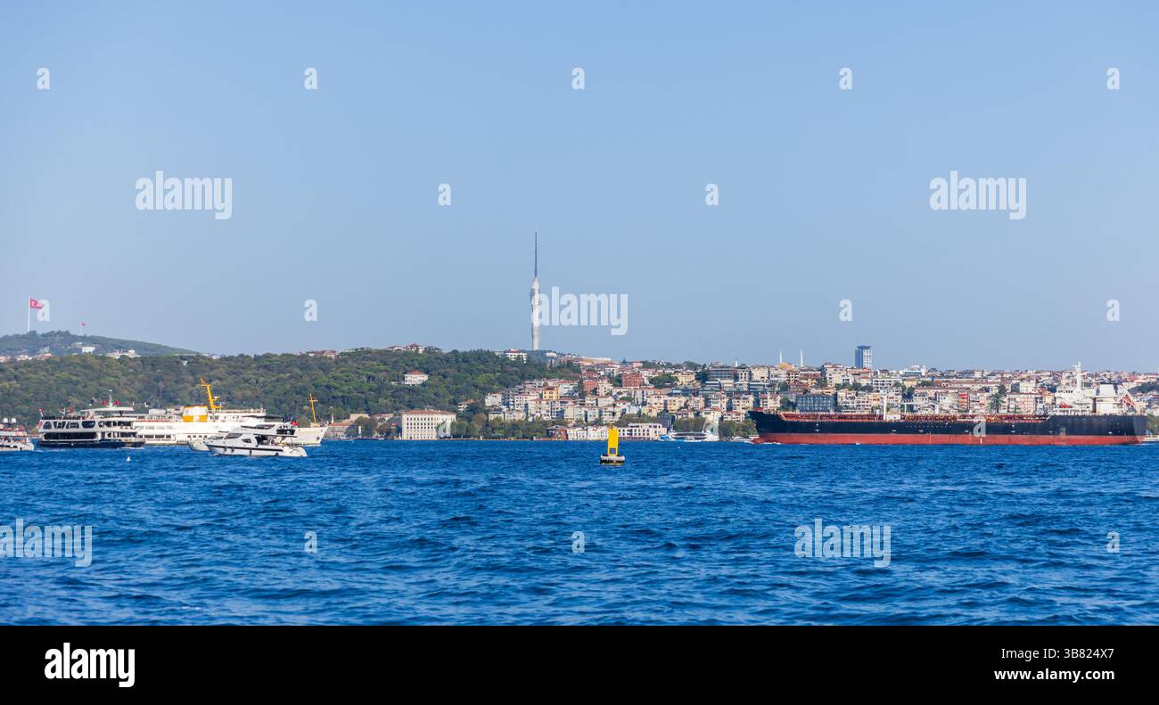 Scena del Bosforo caratterizzata da varie imbarcazioni, architettura urbana costiera e una torre futuristica centrale sotto un cielo azzurro, che incarna la vibrante città li Foto Stock Scena del Bosforo caratterizzata da varie imbarcazioni, architettura urbana costiera e una torre futuristica centrale sotto un cielo azzurro, che incarna la vibrante città li Foto Stock