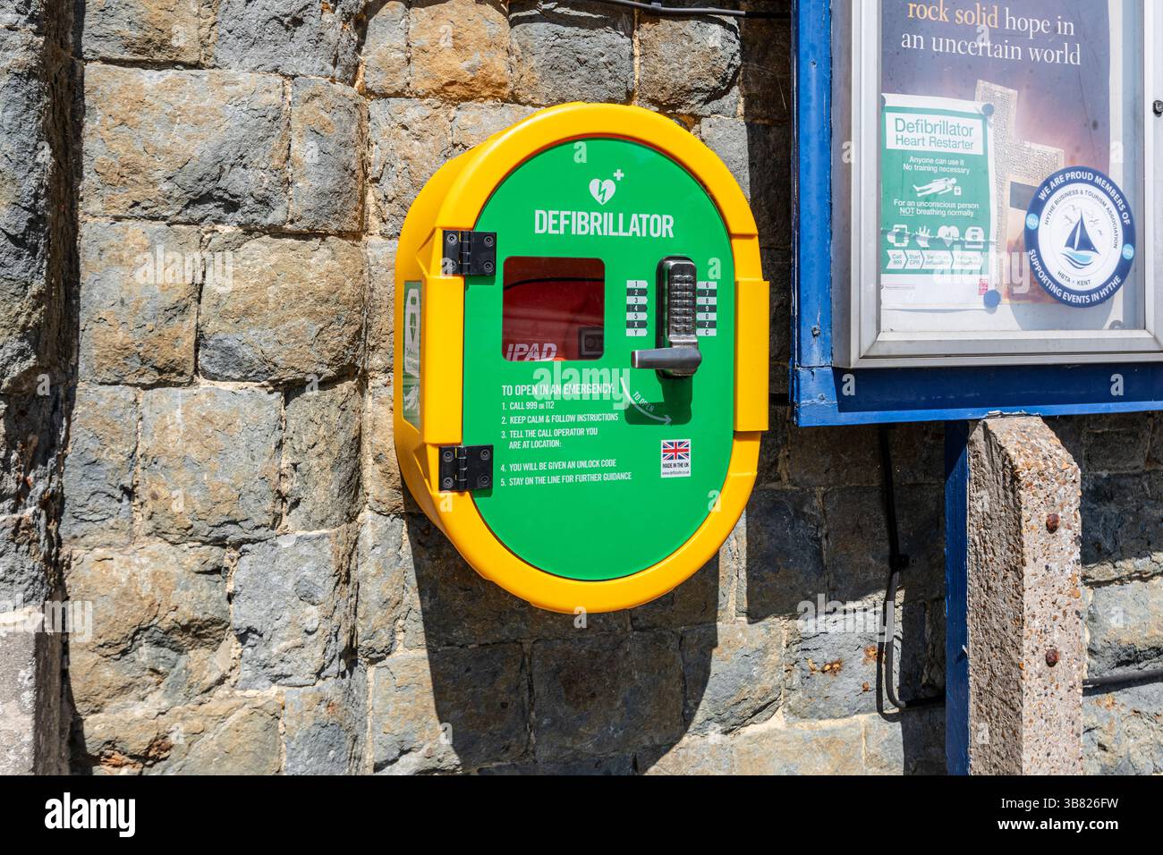 Un defibrillatore pubblico su un muro di pietra Foto Stock