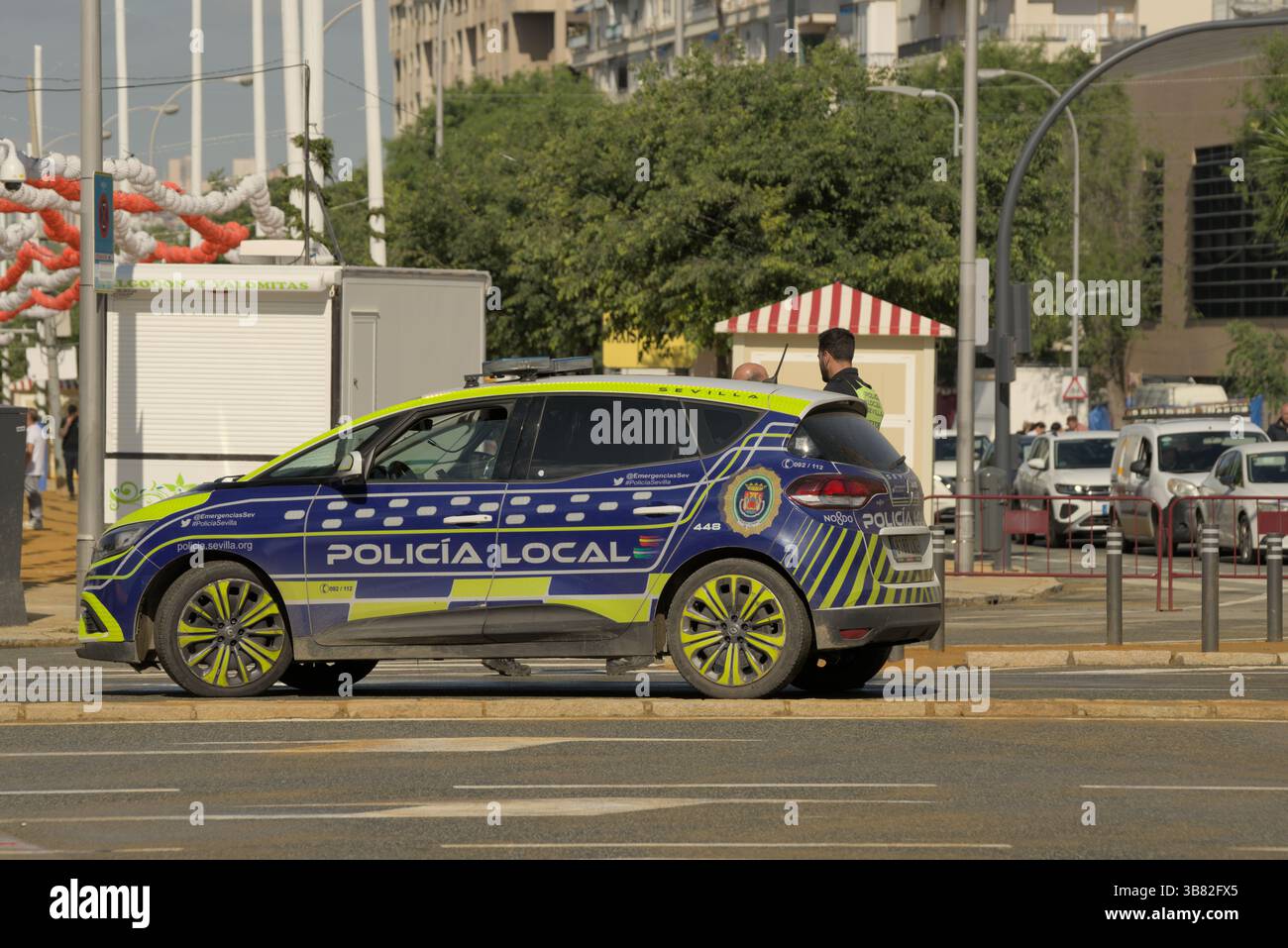 Policía pattuglia locale in servizio a Siviglia, Andalusia, Spagna, con marcature blu e gialle e un ambiente urbano moderno.Siviglia, Spagna Foto Stock