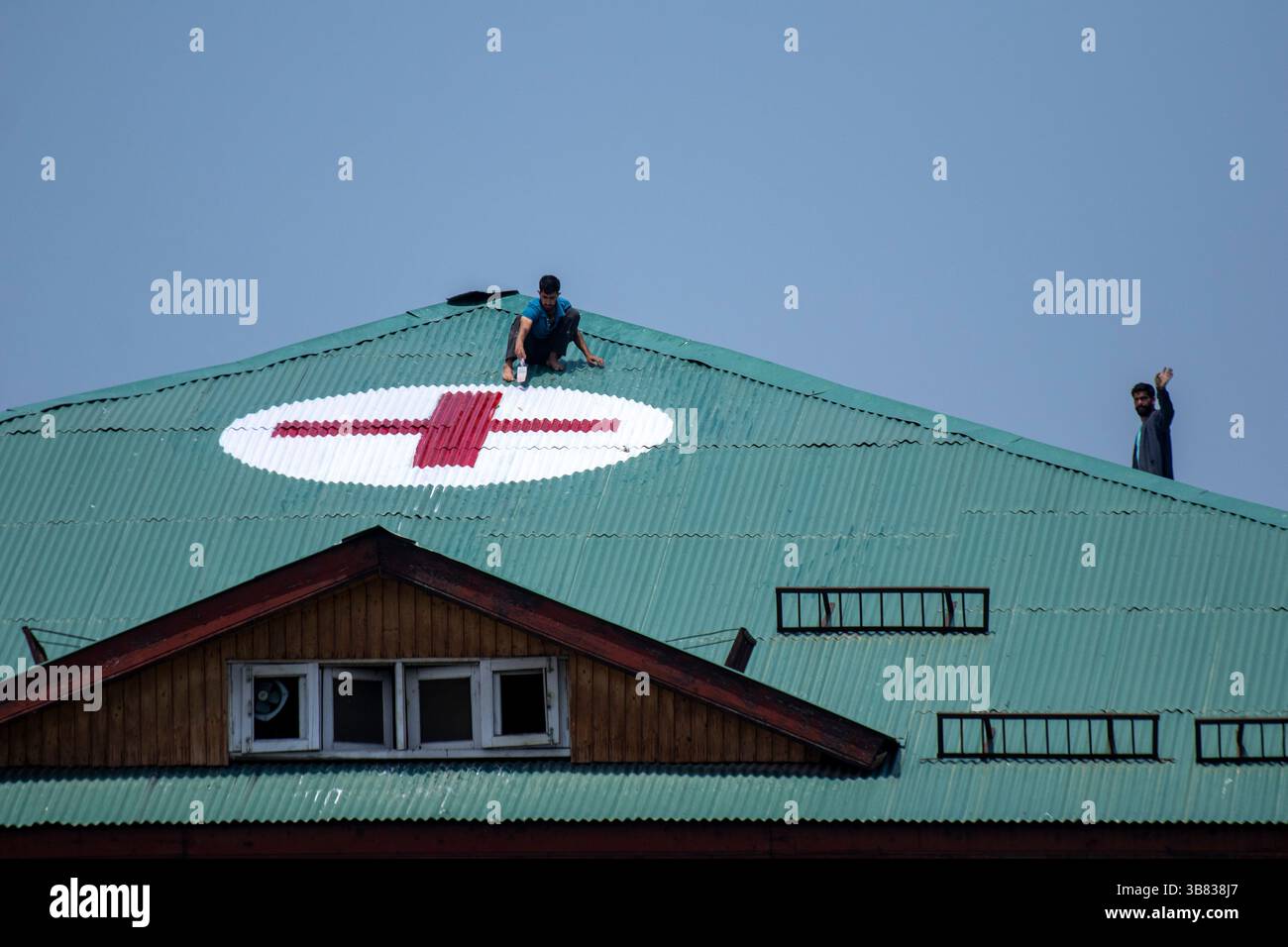Srinagar, India. 7 maggio 2025. I lavoratori kashmiri dipingono un simbolo a croce rossa sul tetto di un ospedale come misura preventiva in mezzo alle tensioni di confine in corso. India e Pakistan si scambiarono artiglieria pesante lungo la loro frontiera contesa il 7 maggio dopo che nuova Delhi lanciò attacchi missilistici mortali sul suo arcinemico, nella peggiore violenza tra i vicini armati di armi nucleari degli ultimi due decenni. (Foto di Faisal Bashir/SOPA Images/Sipa USA) credito: SIPA USA/Alamy Live News Foto Stock