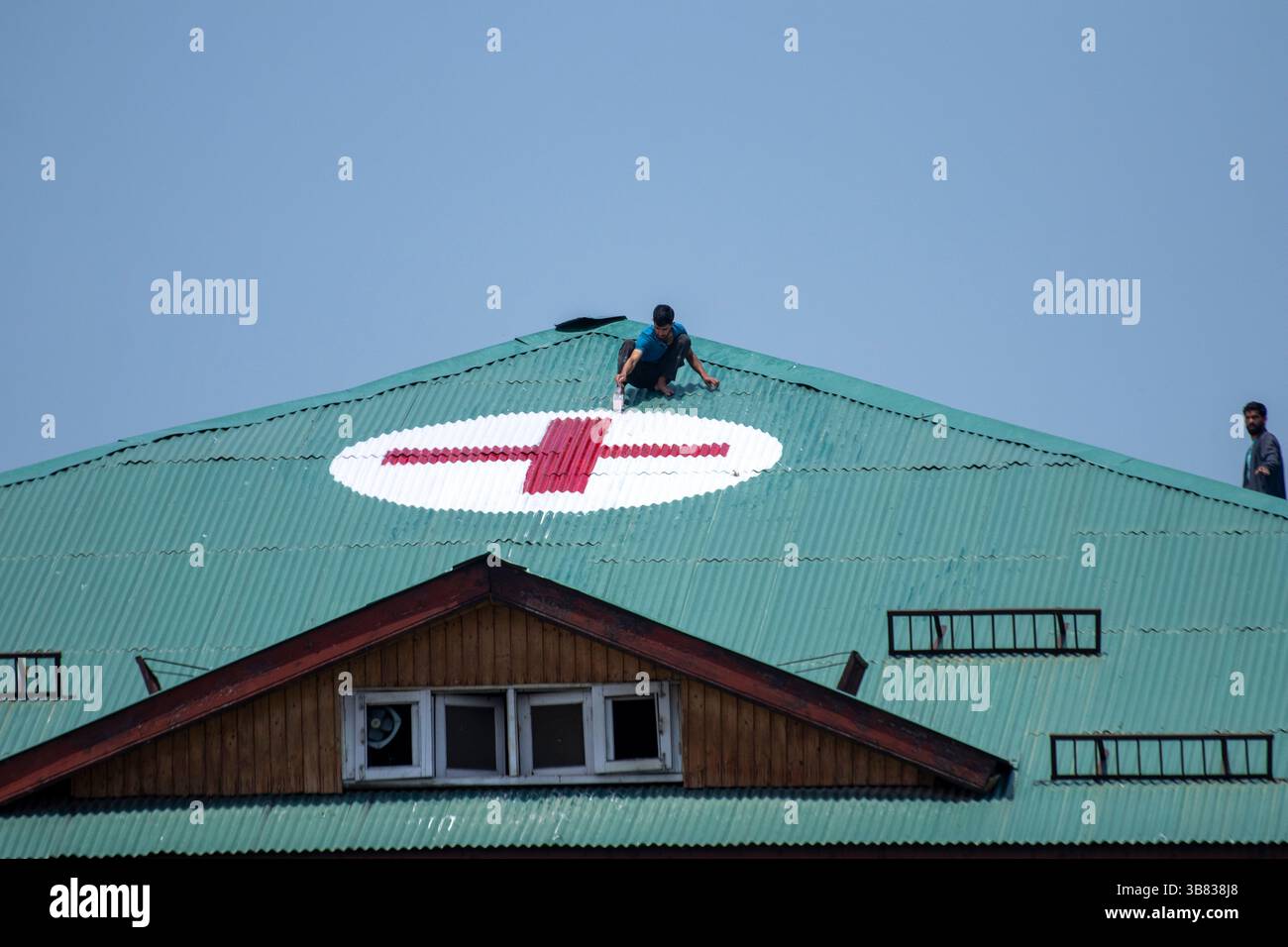 Srinagar, India. 7 maggio 2025. I lavoratori kashmiri dipingono un simbolo a croce rossa sul tetto di un ospedale come misura preventiva in mezzo alle tensioni di confine in corso. India e Pakistan si scambiarono artiglieria pesante lungo la loro frontiera contesa il 7 maggio dopo che nuova Delhi lanciò attacchi missilistici mortali sul suo arcinemico, nella peggiore violenza tra i vicini armati di armi nucleari degli ultimi due decenni. (Foto di Faisal Bashir/SOPA Images/Sipa USA) credito: SIPA USA/Alamy Live News Foto Stock