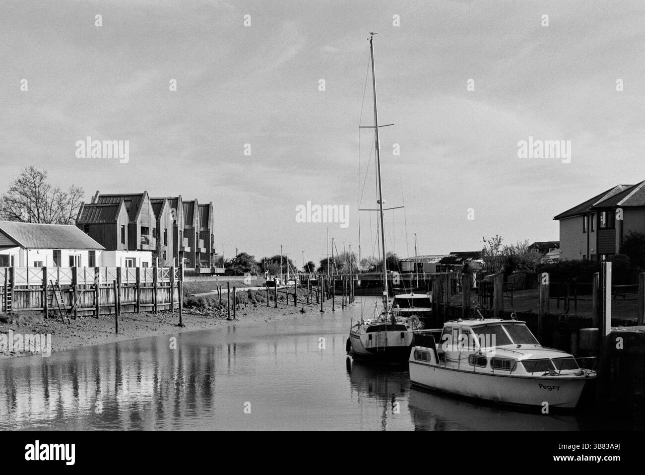Il fiume Brede a Rye, East Sussex, Regno Unito, con barche, in monocromia Foto Stock