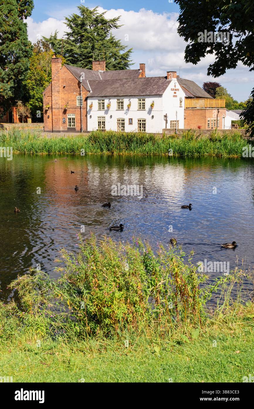 Vista sul fossato del castello fino al pub del villaggio Ye Old Boot Inn nelle Marche gallesi. Whittington, Oswestry, Shropshire, Inghilterra, Regno Unito, Regno Unito Foto Stock