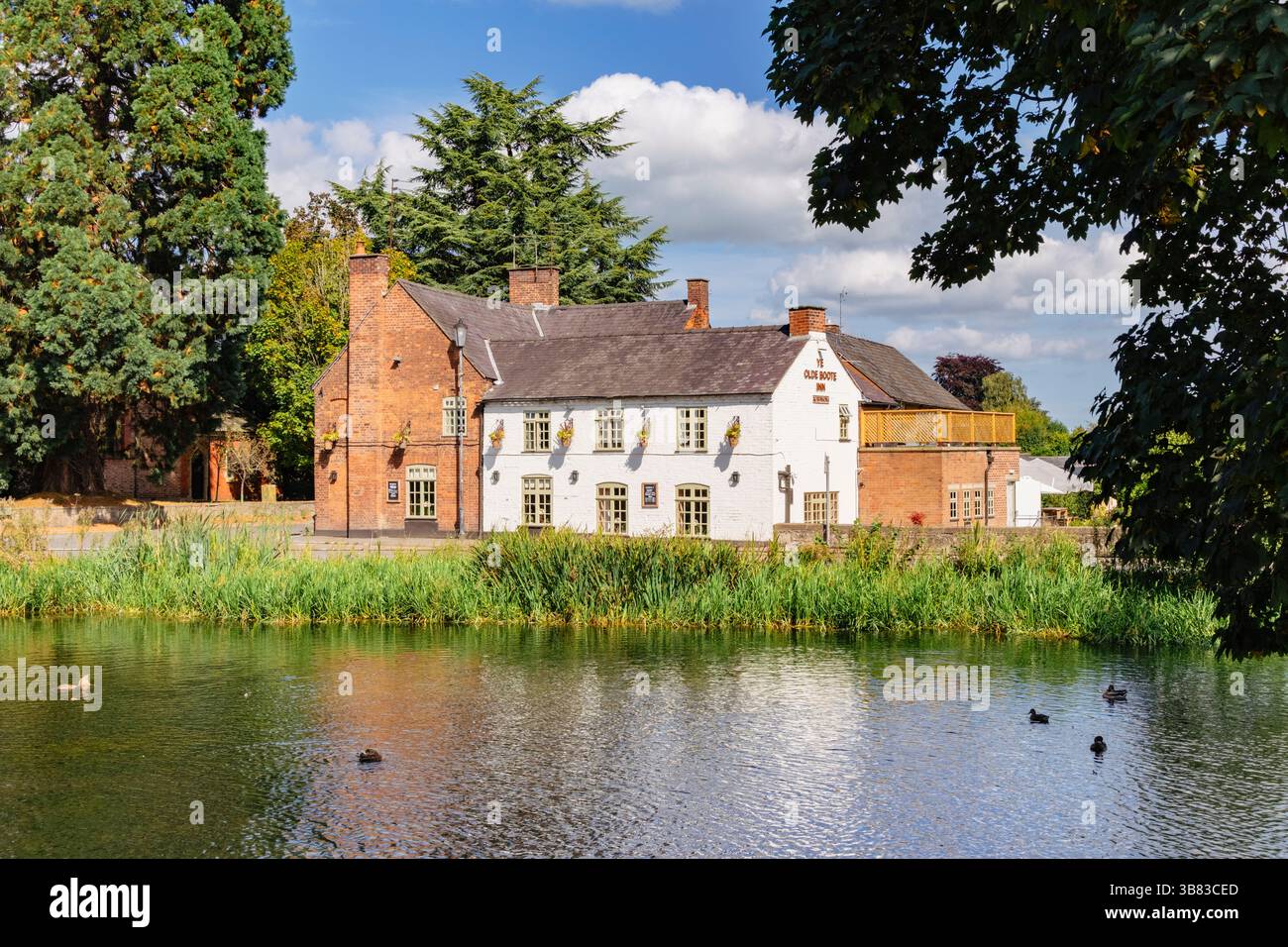 Vista sul fossato del castello fino al pub del villaggio Ye Old Boot Inn nelle Marche gallesi. Whittington, Oswestry, Shropshire, Inghilterra, Regno Unito, Regno Unito Foto Stock