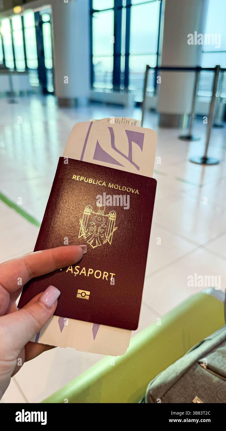 Donna in possesso di un passaporto della repubblica di moldova con biglietto aereo al terminal dell'aeroporto, che riflette i viaggi e i viaggi internazionali. Foto Stock