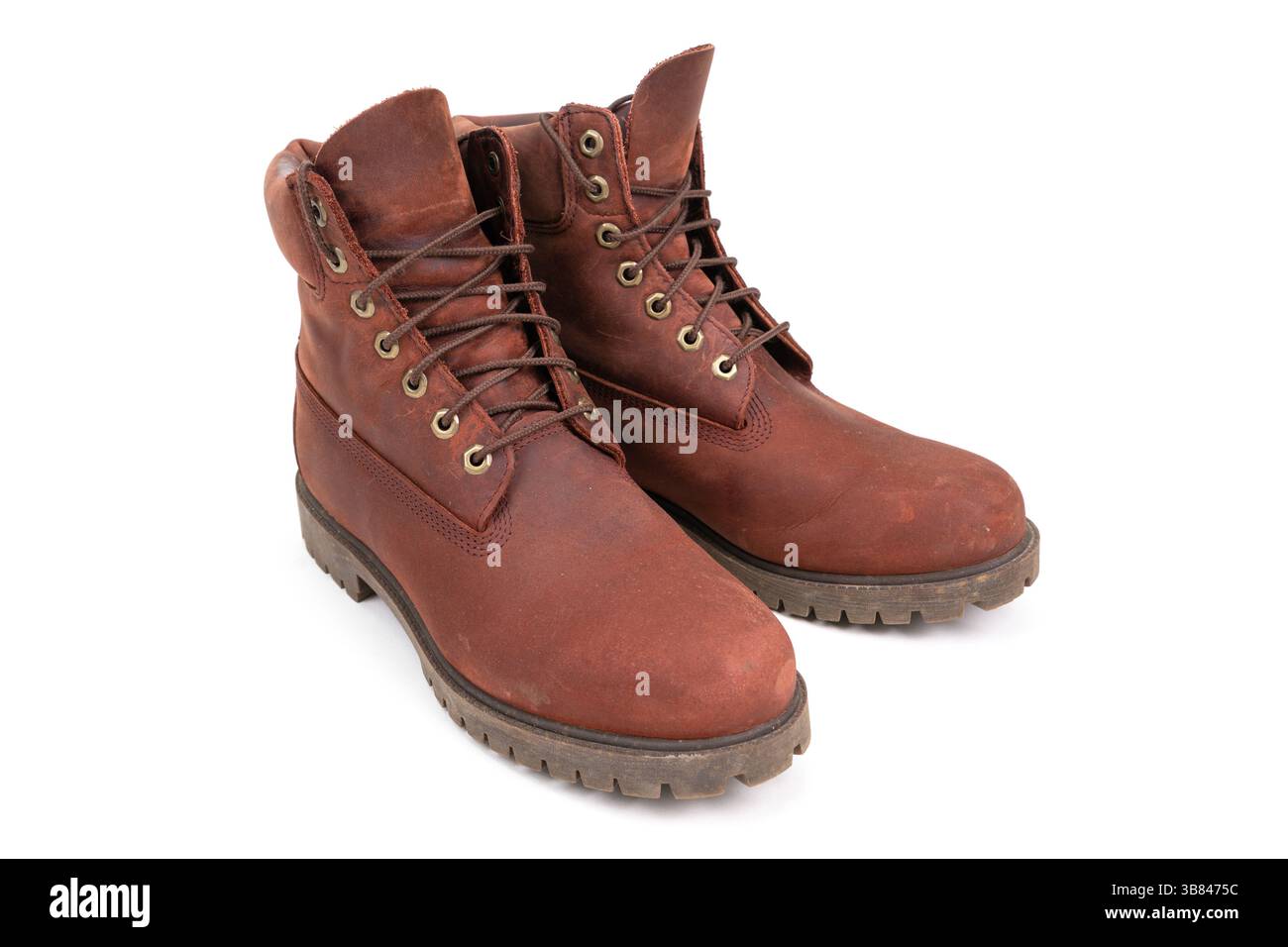 Un paio di stivali in pelle marrone indossati isolati su sfondo bianco Foto Stock