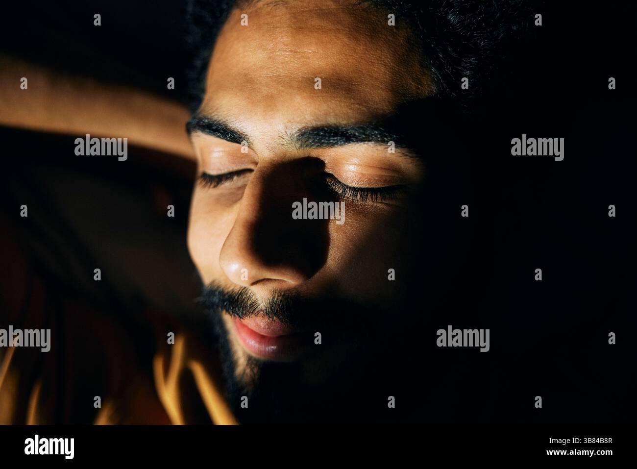 Primo piano della luce del sole che splende sul viso dell'uomo Foto Stock