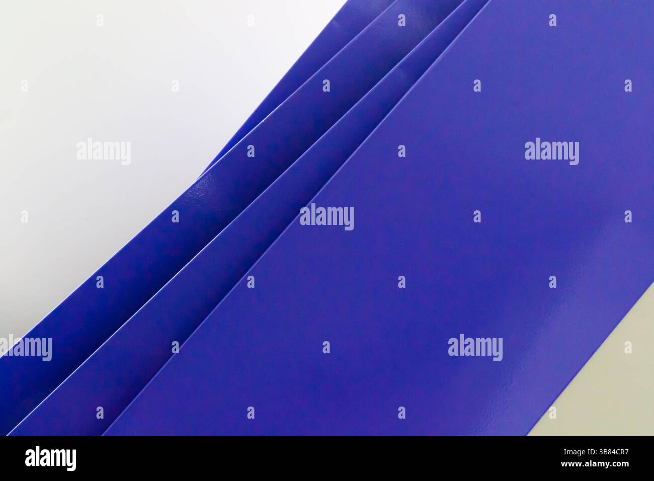 composizione diagonale geometrica e astratta formata da ripiani blu disposti su una parete bianca, con una serie di linee diagonali Foto Stock