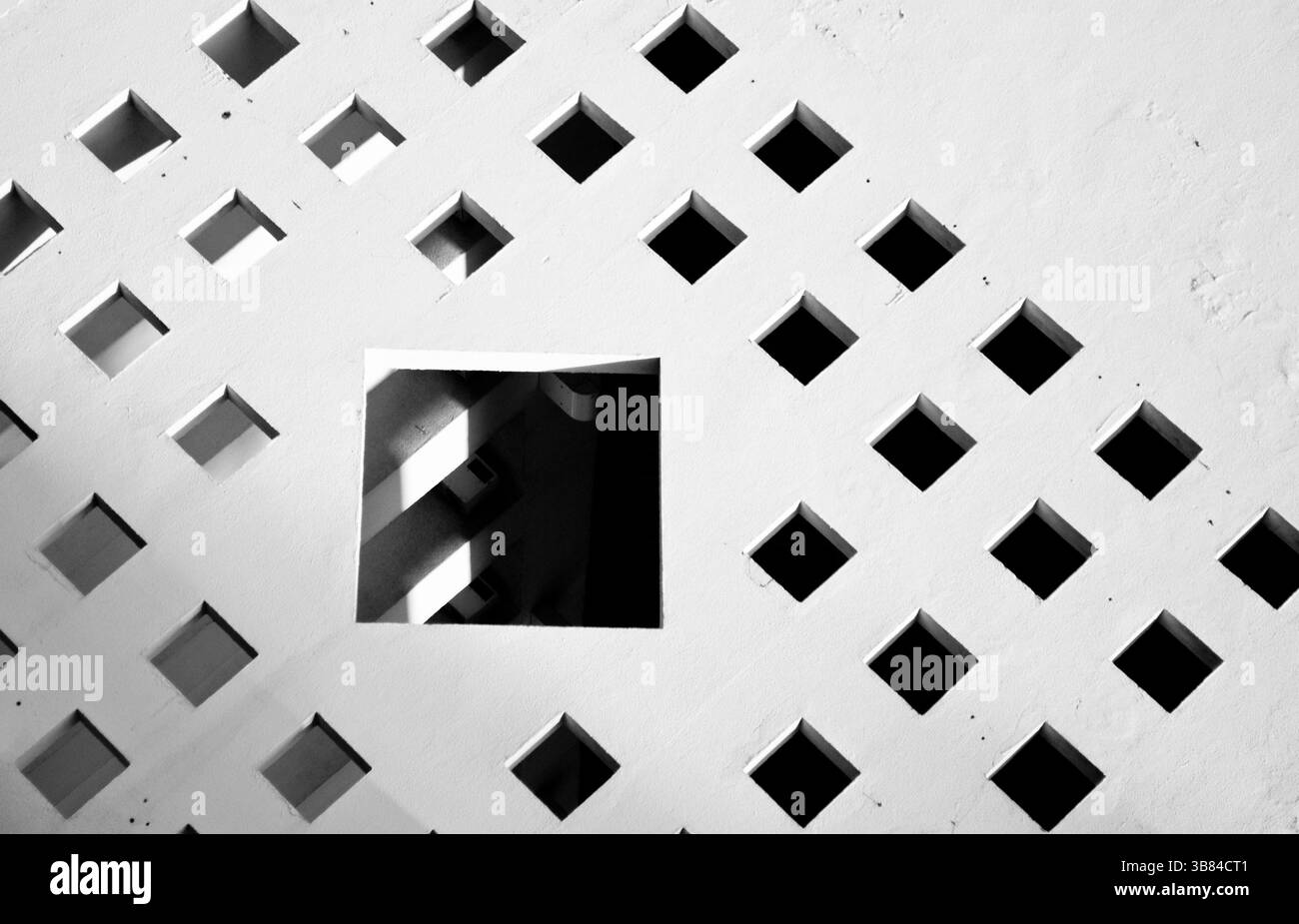 composizione astratta formata da un muro bianco con diverse piccole finestre intorno ad una grande finestra Foto Stock