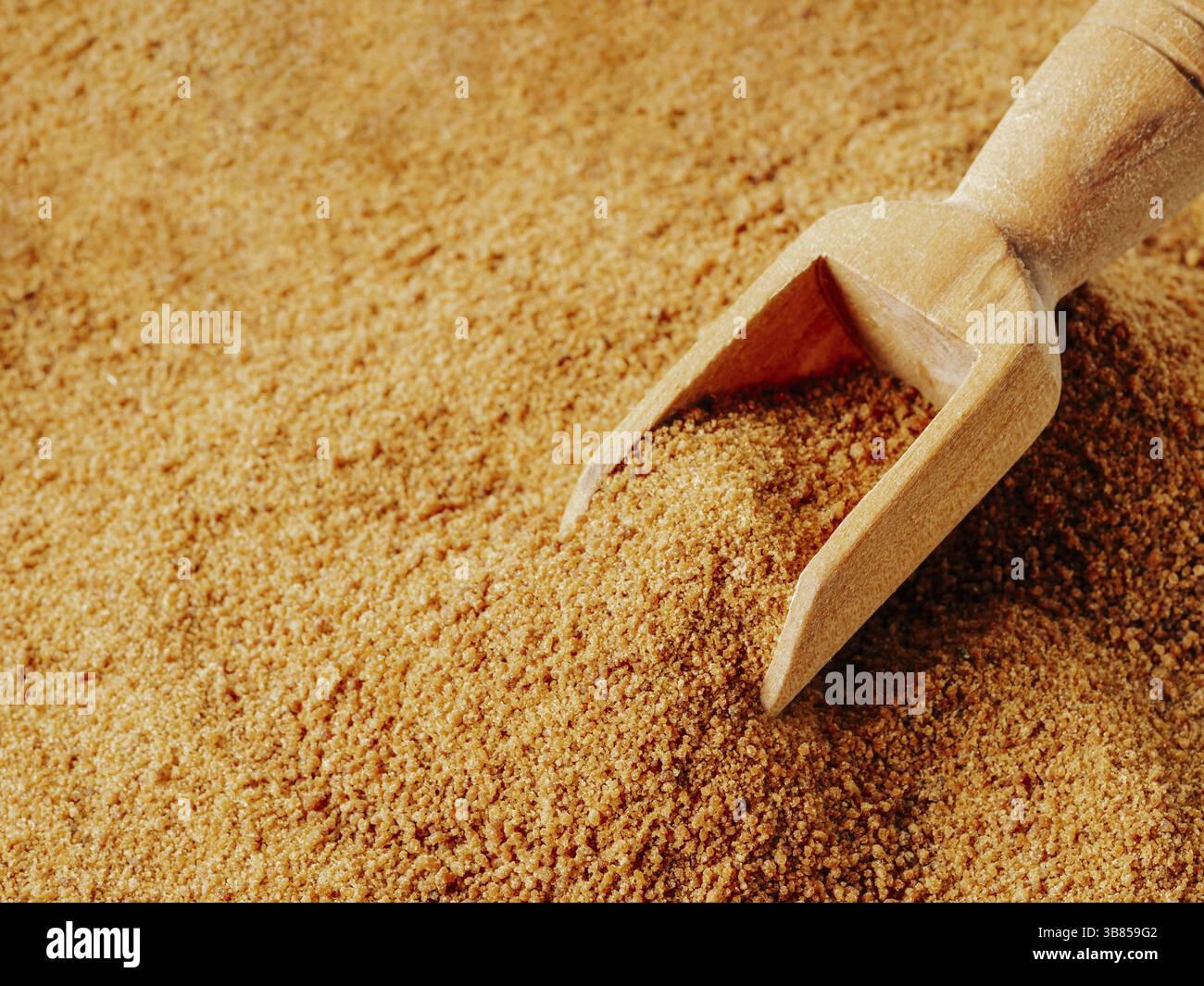 Consistenza di fondo di zucchero di cocco grezzo organico da linfa cristallizzata di boccioli di fiori tagliati palma di cocco. Zucchero di palma di cocco marrone e paletta di legno. Alte Foto Stock