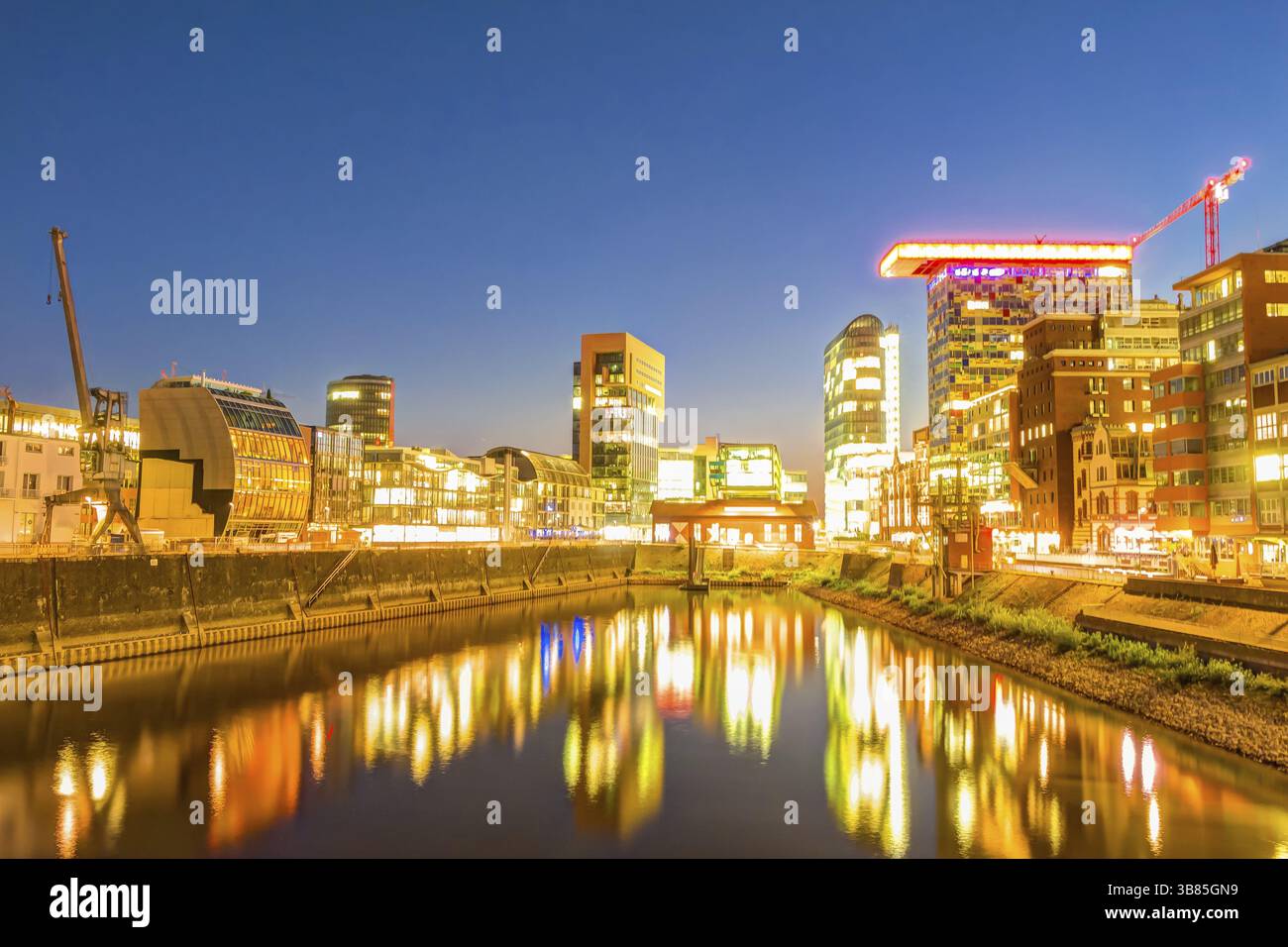 Medienhafen a Duesseldorf zur Abenddaemmerung und in voller Beleuchtung Foto Stock