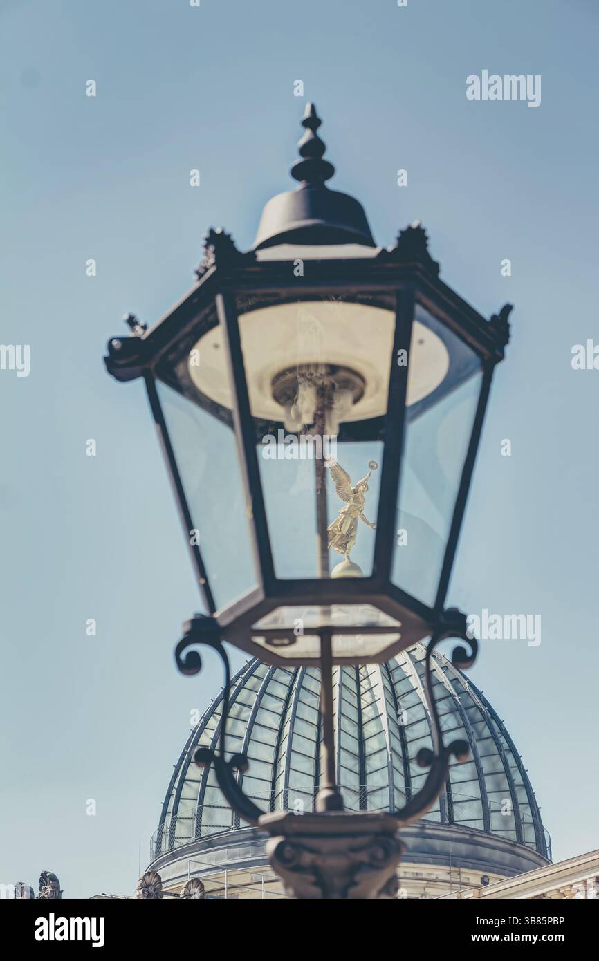 Blick durch eine historische Strassenlaterne auf die Glaskuppel der Hochschule fuer Bildende Kuenste mit der goldenen fama a Dresda Foto Stock