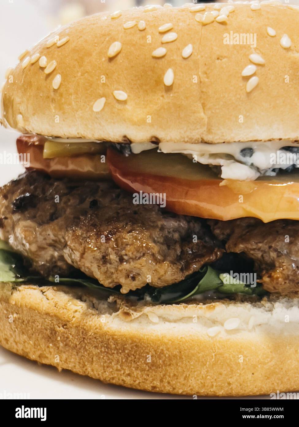 Gustoso cheeseburger con formaggio e insalata verde. Foto Stock