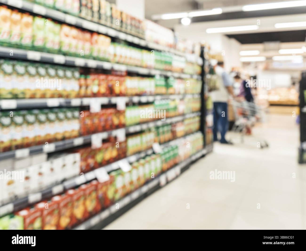 Abstract supermercato sfocata corsia con ripiani colorati e i clienti non riconoscibile come sfondo Foto Stock