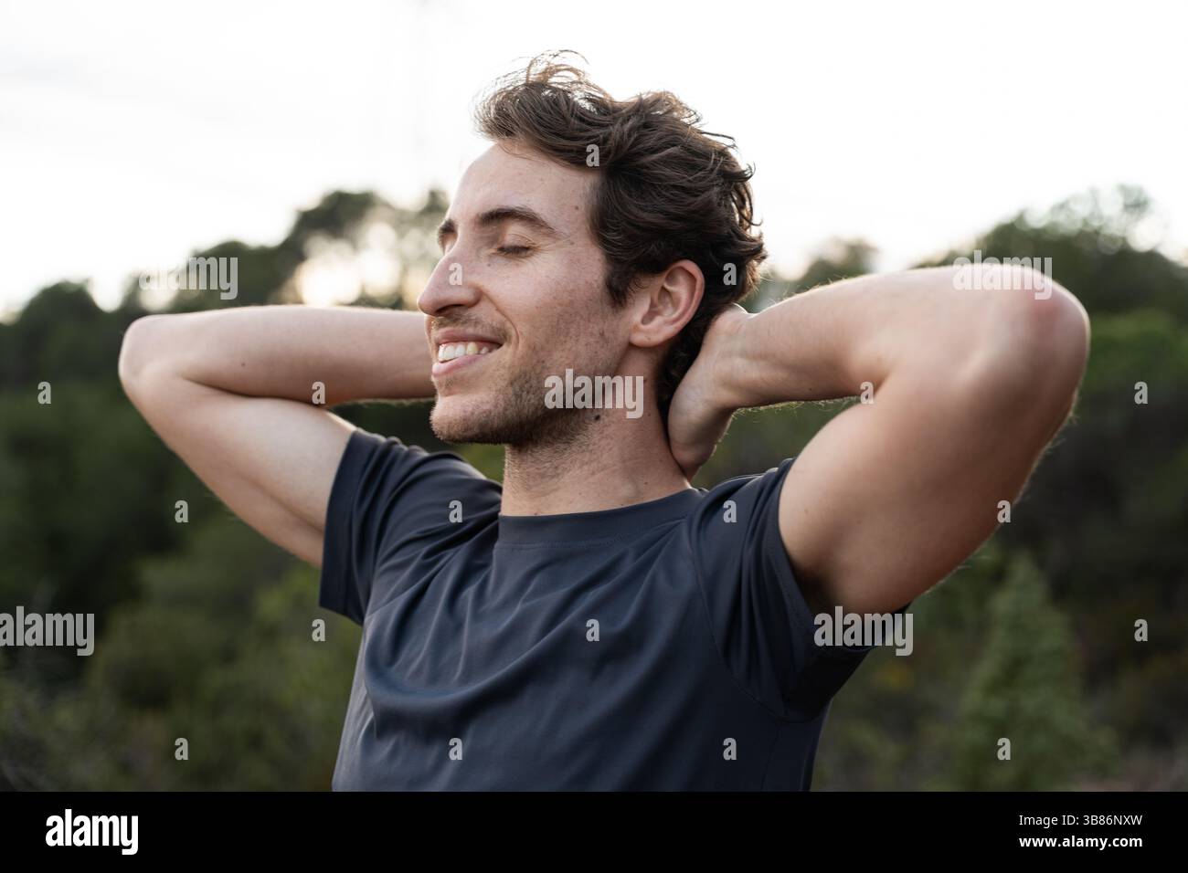 Un uomo respira aria fresca in natura. Stile di vita sano e benessere emotivo. Foto Stock
