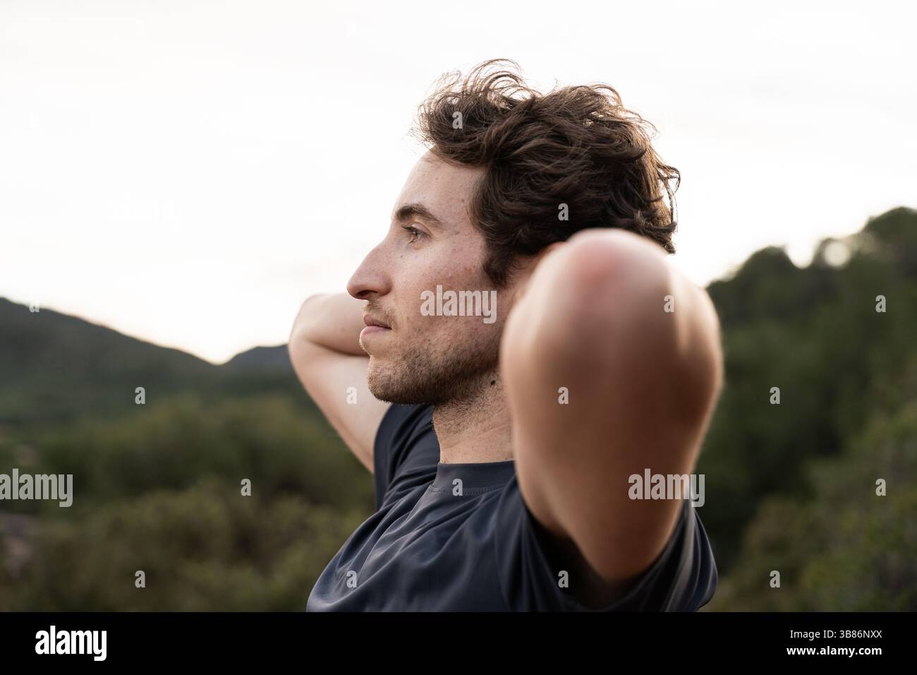 Uomo attraente che respira aria fresca all'aperto. Assistenza sanitaria e benessere Foto Stock