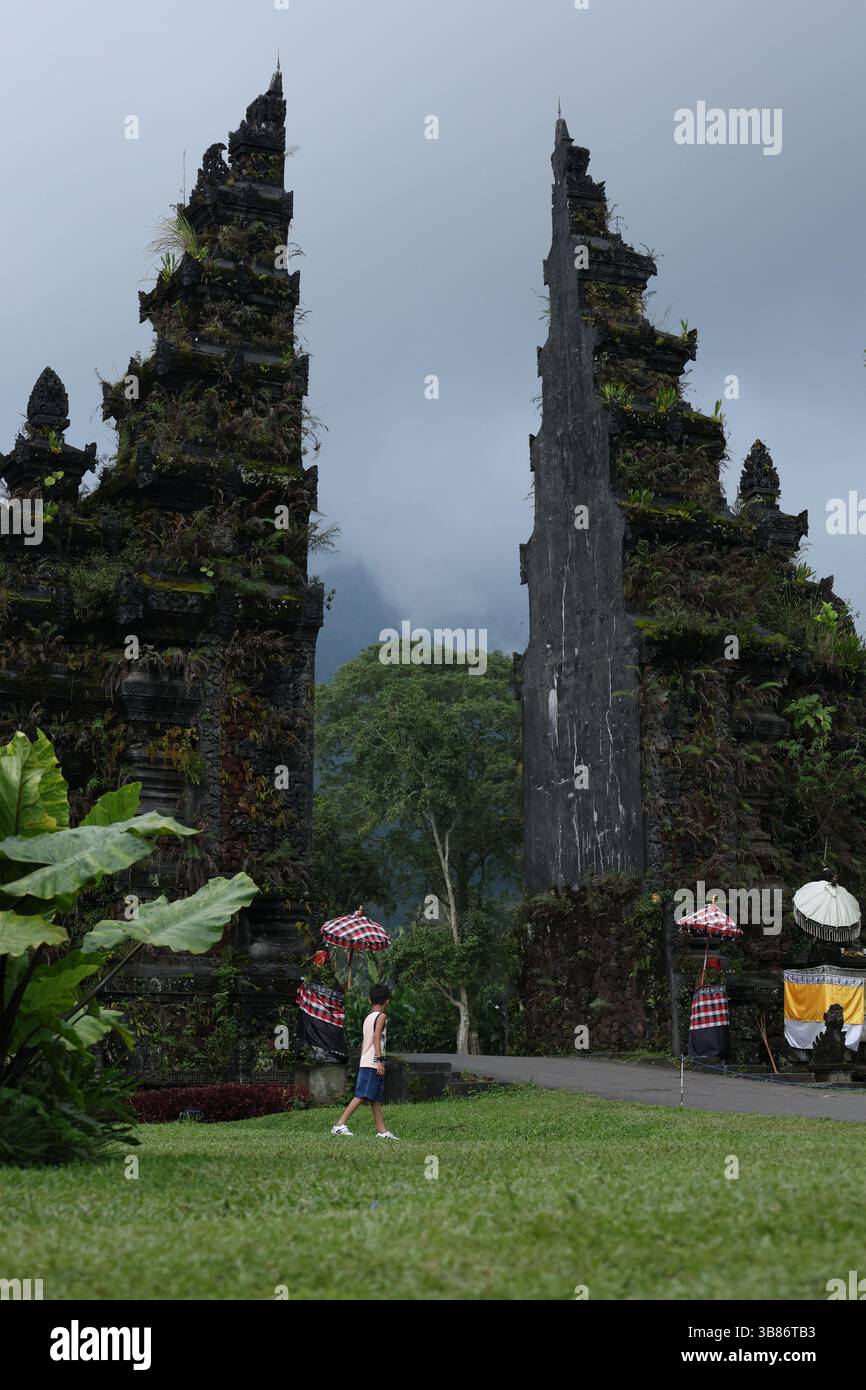 Tradizionale porta balinese di Handara con vegetazione lussureggiante e Montagne nebbiose, Bali, Indonesia Foto Stock