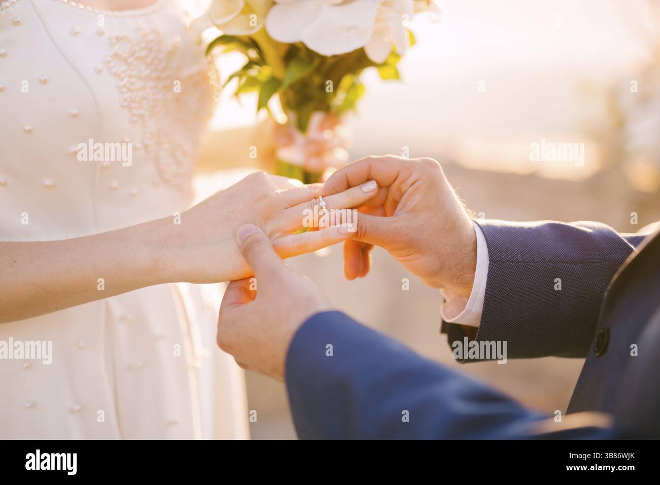Lo sposo mette l'anello al dito della sposa durante la cerimonia nuziale. Foto Stock