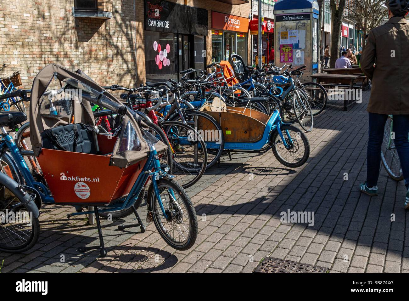 Molte biciclette, tra cui portabiciclette e cargo, sono parcheggiate in appositi portabiciclette su Fitzroy Street, vicino al Grafton Centre, Cambridge, Inghilterra, Regno Unito Foto Stock