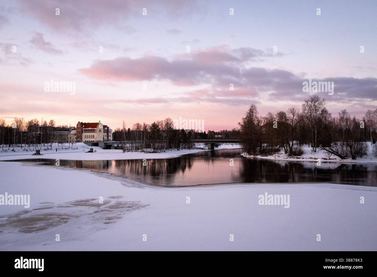 Paesaggio del fiume Pielisjoki ghiacciato al tramonto a Joensuu nella Carelia settentrionale in Finlandia il 13 marzo 2025. Joensuu è conosciuta come la silvicoltura europea Foto Stock