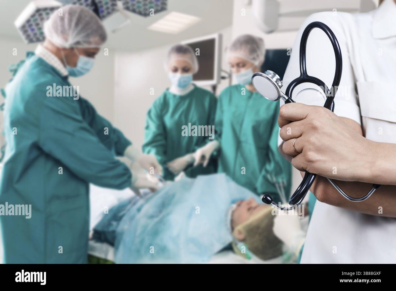 Medico che tiene lo stetoscopio sopra il team di chirurghi durante un intervento chirurgico Foto Stock