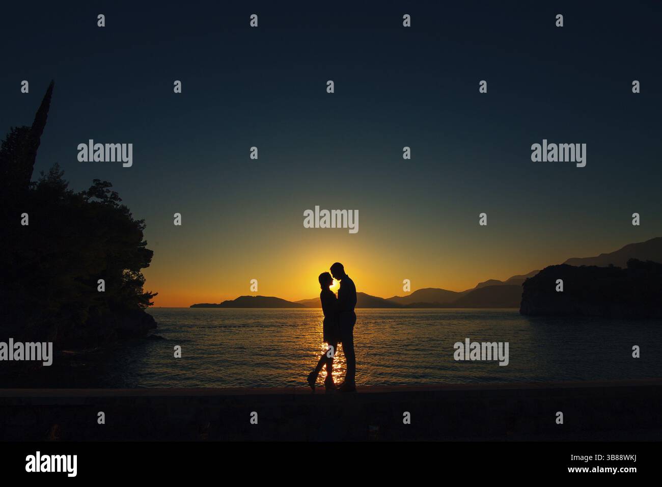 Sagome al tramonto sulla spiaggia in Montenegro Foto Stock