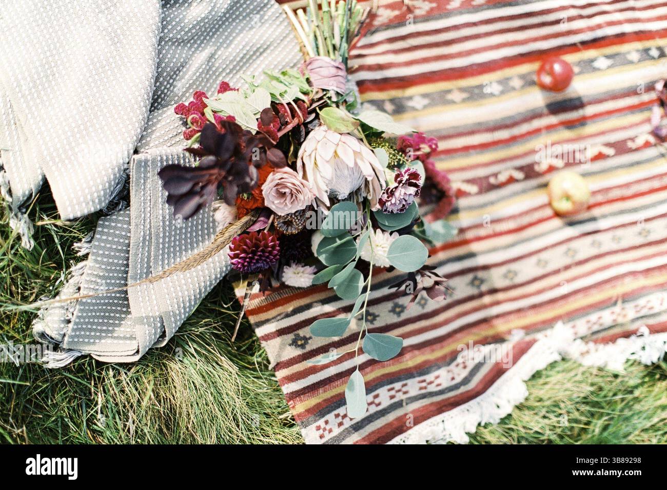 Il bouquet nuziale si trova su un copriletto casalingo. Foto Stock