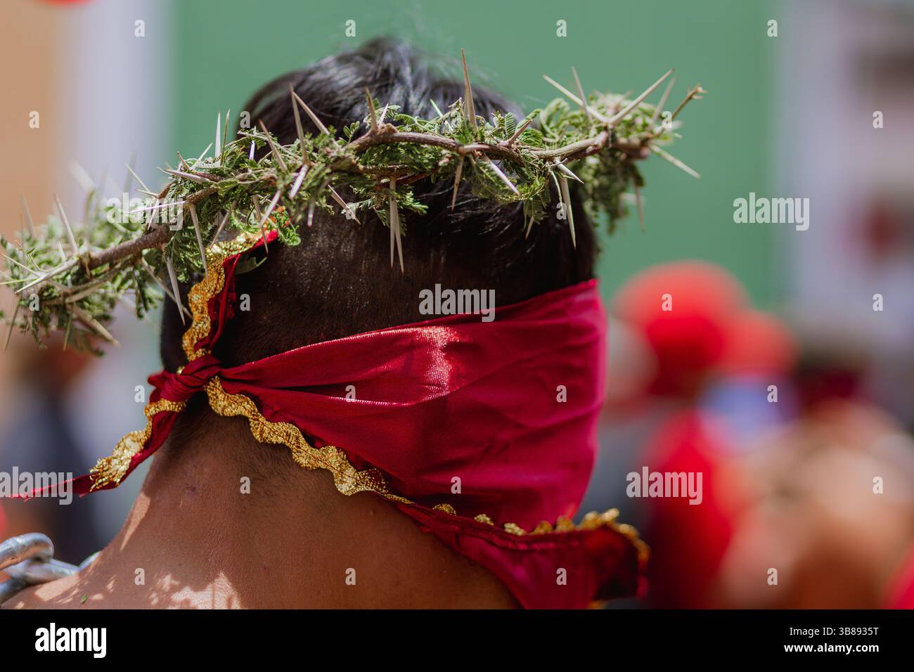 Primo piano della testa di un uomo durante la tradizione degli Engrillados ad Atlixco, Messico. La corona di spine e il volto ricoperto di rosso simboleggiano fede e dolore Foto Stock