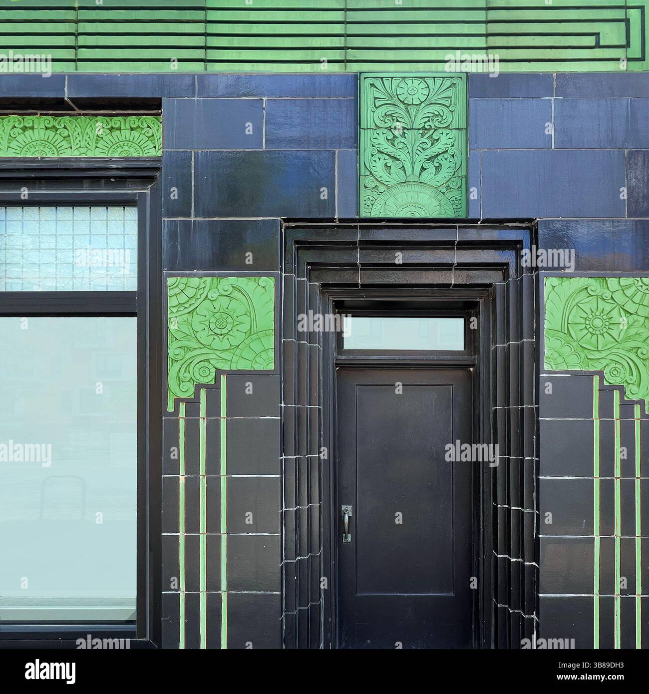 Ingresso Art Deco con piastrelle nere con pannelli ornamentali verdi vividi e dettagli geometrici stilizzati a Chicago - Immagine stock catturata con smartphone