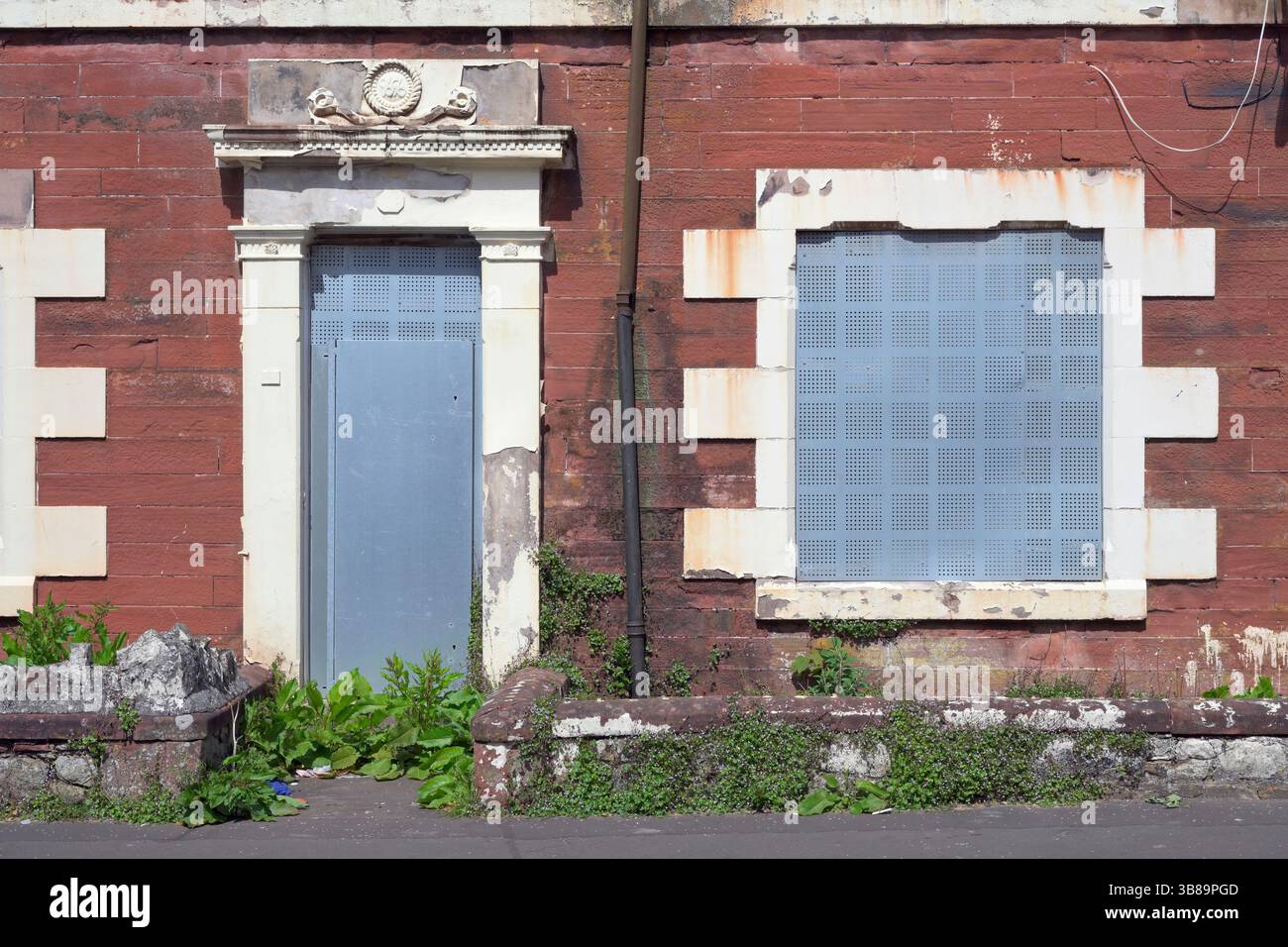Edificio abbandonato con persiane in acciaio su porta e finestra, Regno Unito Foto Stock