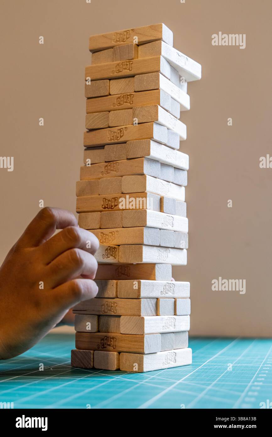 Bath, Regno Unito - 5 ottobre 2024: Gioco di Jenga con blocchi di legno su tappetino da taglio verde. Foto Stock