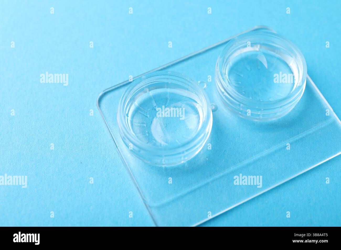 Lenti a contatto in astuccio su sfondo azzurro, primo piano Foto Stock