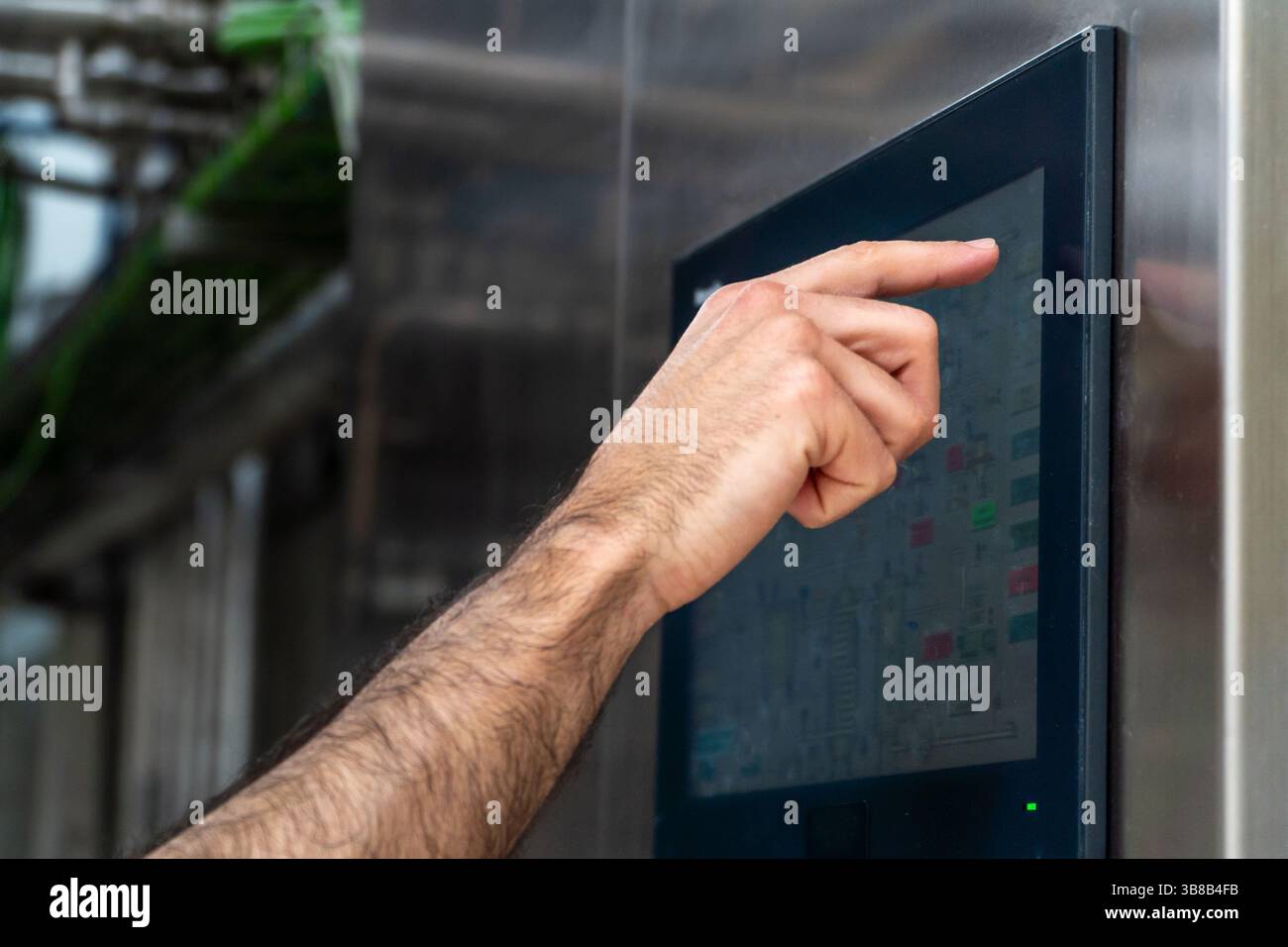 Operaio che utilizza il pannello di controllo sulla linea di produzione Foto Stock