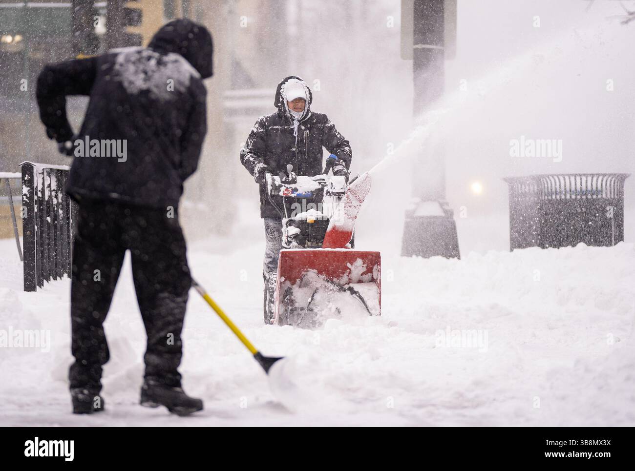 23 febbraio 2023, Minneapolis, Minnesota, Stati Uniti: Luis Cabrera e Carlos Toro, da sinistra a destra, neve limpida sul marciapiede di fronte al Butcher's tale il 23 febbraio 2023, a Minneapolis. (Immagine di credito: © Alex Kormann/Minneapolis Star Tribune via ZUMA Press Wire) Foto Stock