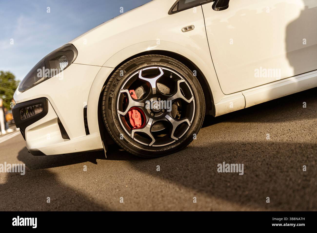 Roma, italia 4 maggio 2025: Primo piano di un'auto sportiva bianca parcheggiata su asfalto, con cerchi in lega, pinze dei freni rosse e pneumatici a profilo ribassato Foto Stock