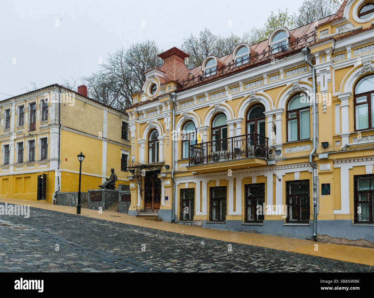 Kiev, Ucraina - 7 aprile 2025: Vista della discesa Andriyivskyy e del Monumento Mykola Hohol durante una nevicata leggera Foto Stock