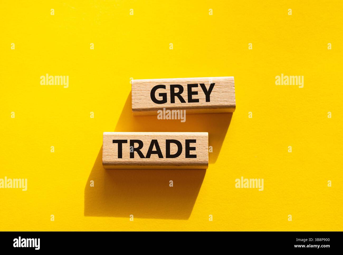 Simbolo commerciale grigio. Blocchi di legno con parole "commercio grigio". Bellissimo sfondo giallo. Business e concetto di commercio grigio. Copia spazio. Foto Stock