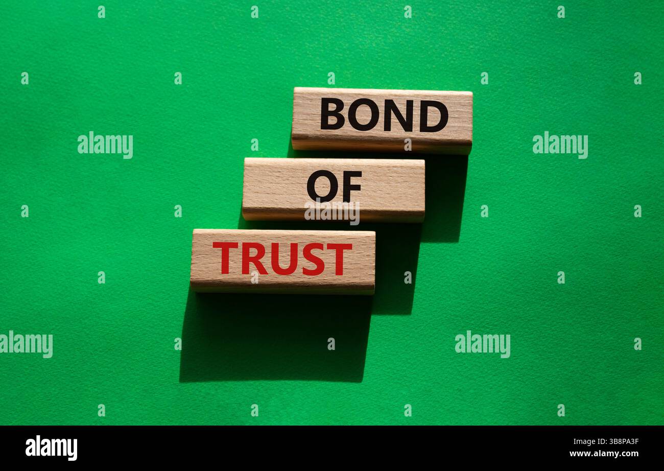 Simbolo del legame di fiducia. Blocchi di legno con parole Bond of Trust. Bellissimo sfondo verde. Business e Bond of Trust. Copia spazio. Foto Stock