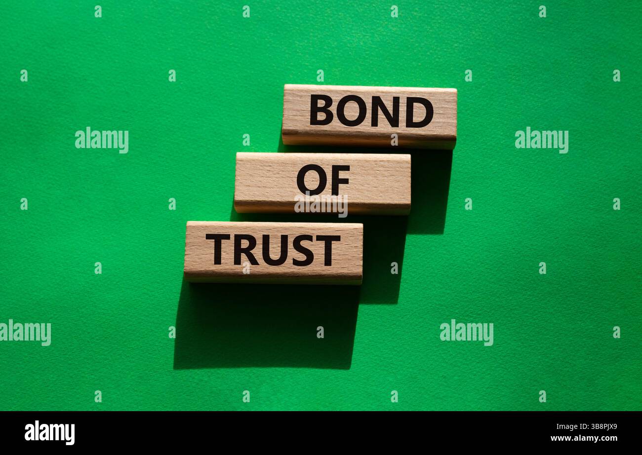 Simbolo del legame di fiducia. Blocchi di legno con parole Bond of Trust. Bellissimo sfondo verde. Business e Bond of Trust. Copia spazio. Foto Stock