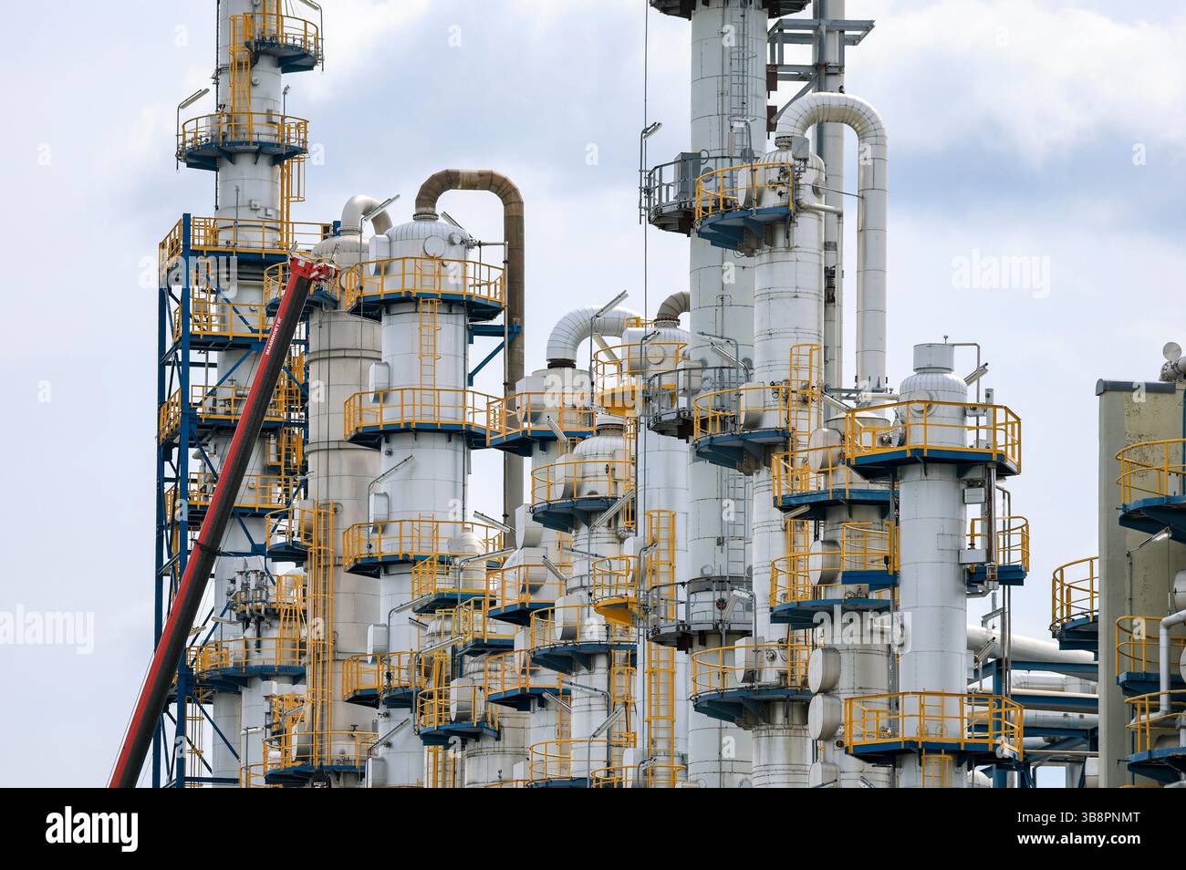 Leuna, Germania. 8 maggio 2025. Una gru si trova accanto alle colonne durante il normale ciclo di lavoro. Circa 550 dipendenti del sito producono i prodotti intermedi cumene, fenolo, acetone, cicloesanone, caprolattame e solfato di ammonio fino alla poliammide 6. La produzione è stata interrotta come previsto per le prossime tre settimane per lavori di manutenzione, pulizia e conversione. Nello stabilimento lavoreranno anche circa 50 aziende esterne con altri 600 dipendenti. Crediti: Jan Woitas/dpa/Alamy Live News Foto Stock