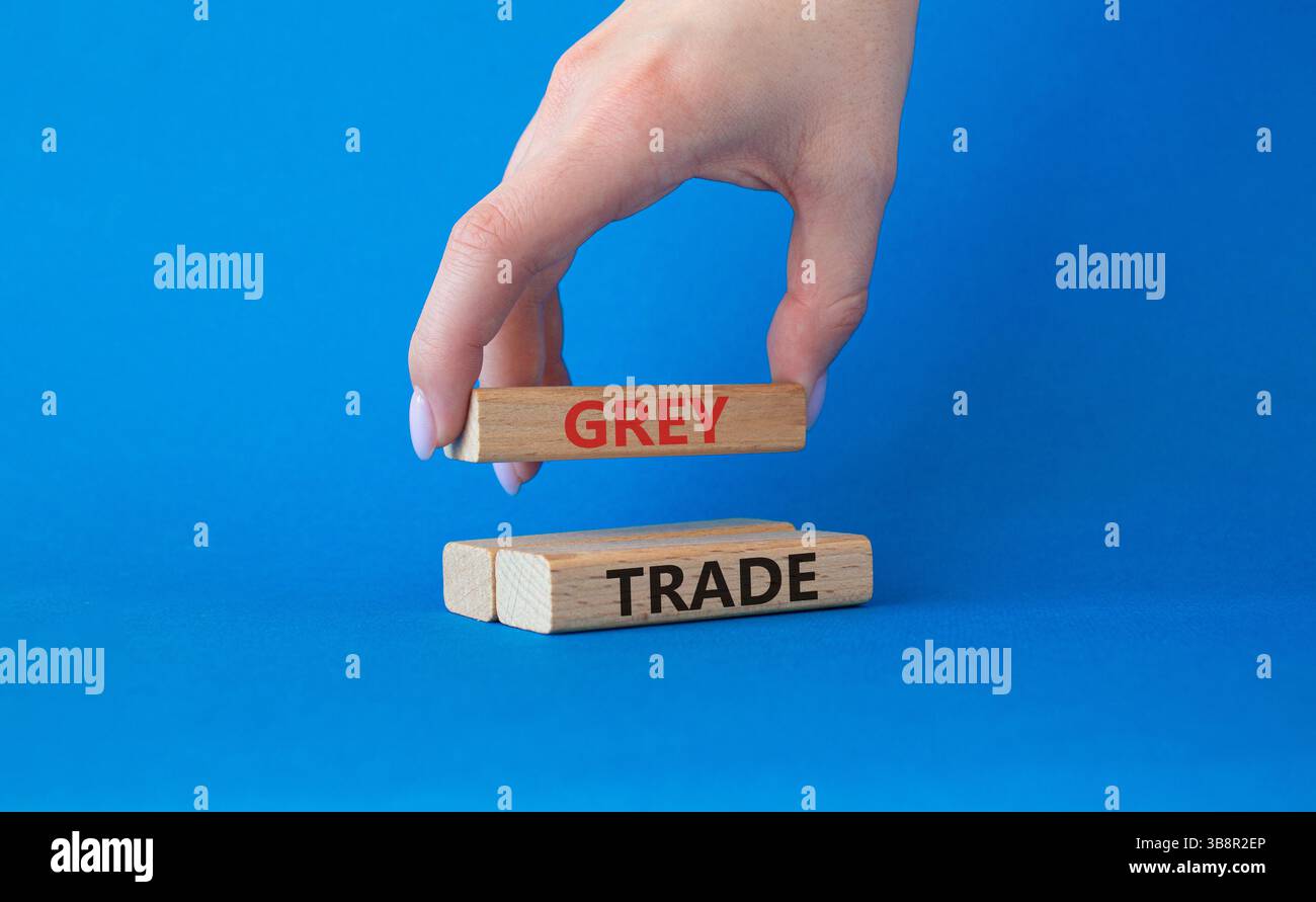 Simbolo commerciale grigio. Blocchi di legno con parole "commercio grigio". Bellissimo sfondo blu. Mano d'affari. Business e concetto di commercio grigio. Copia spazio. Foto Stock