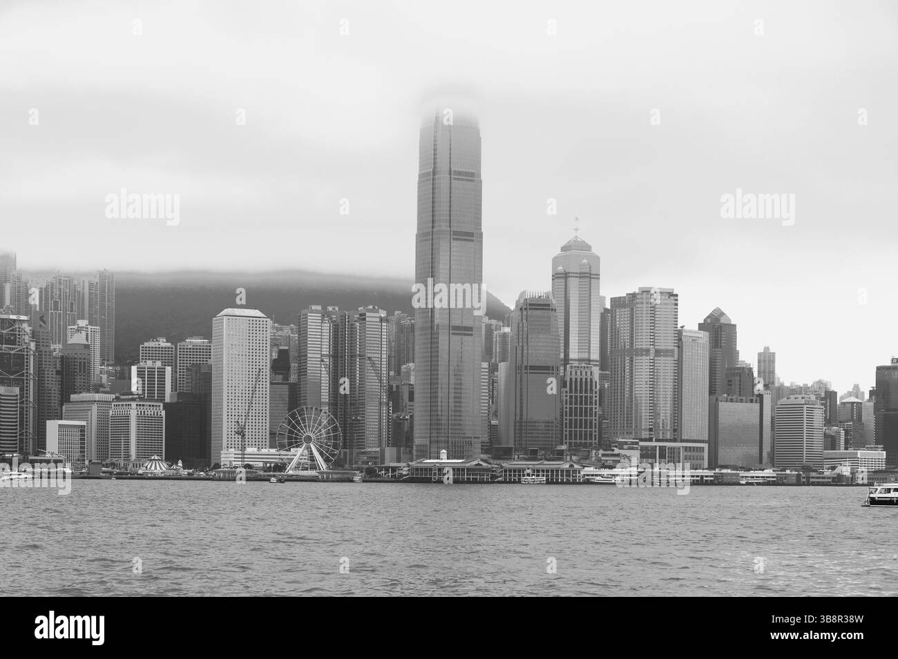 I grattacieli nebbiosi sorgono dallo skyline dell'isola di Hong Kong, parzialmente velati dalle nuvole Foto Stock