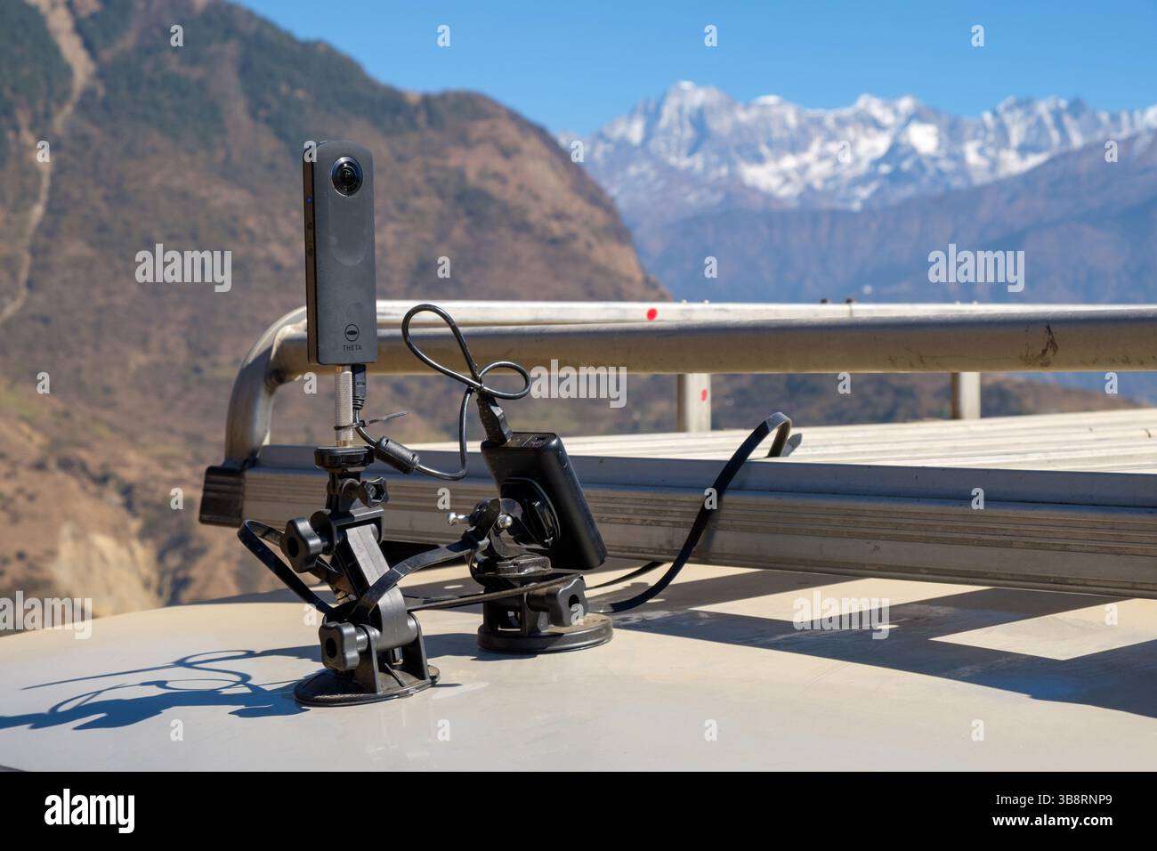 Una telecamera Theta è montata su un portapacchi dell'auto per catturare riprese a 360° del paesaggio montano circostante. Foto Stock