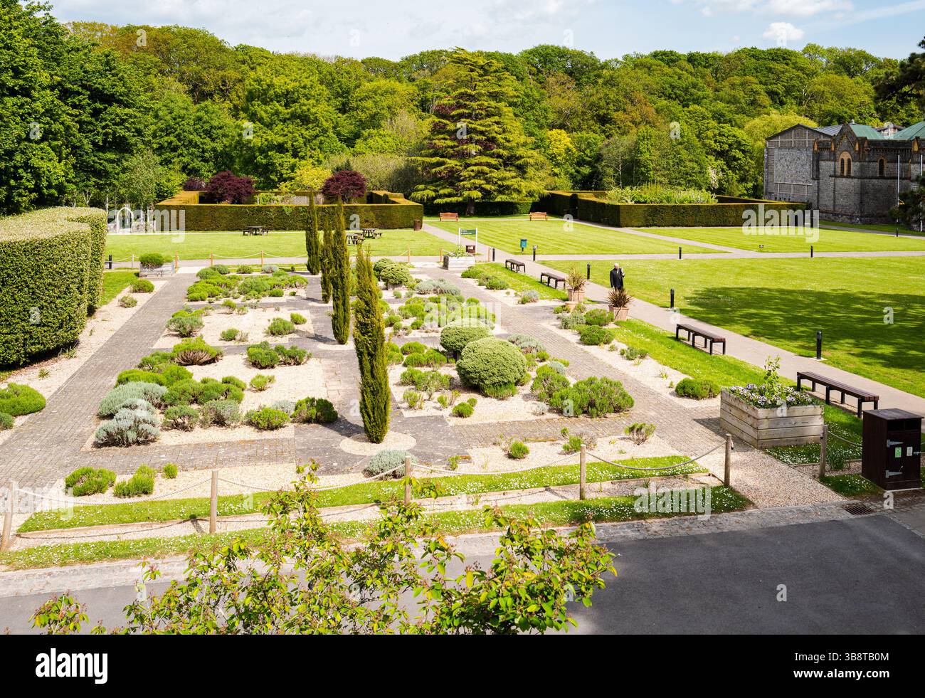 Buckfast abbazia con giardini formali con una persona che cammina. Foto Stock