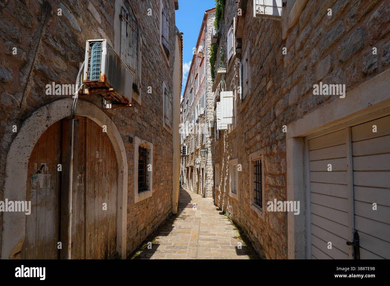 Stretta strada lastricata nella città vecchia di Budva, una città costiera fortificata costruita dalla Repubblica di Venezia lungo la costa del mare Adriatico in Montenegro Foto Stock